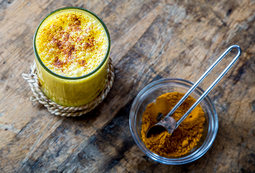 Foto: Glas mit goldener Milch (Kurkuma Latte) auf einer Küchenarbeitsplatte